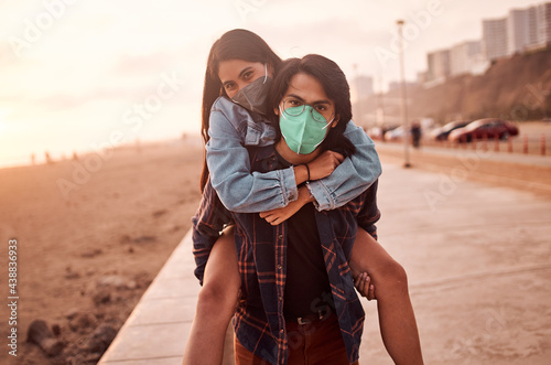 Pareja de jóvenes enamorados caminan por la playa durante un bello atardecer.. Jóvenes felices jugando en malecón de la playa. Amor de pareja