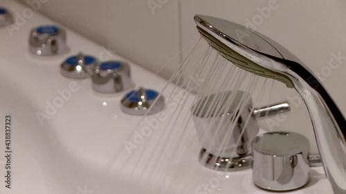 Showerhead spraying water in to a bathtube photo