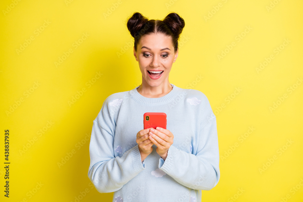 Portrait of attractive amazed cheerful girl using device chatting media news comment isolated over vibrant yellow color background Portrait of attractive amazed cheerful girl using device chatting media news comment isolated over vibrant yellow color background