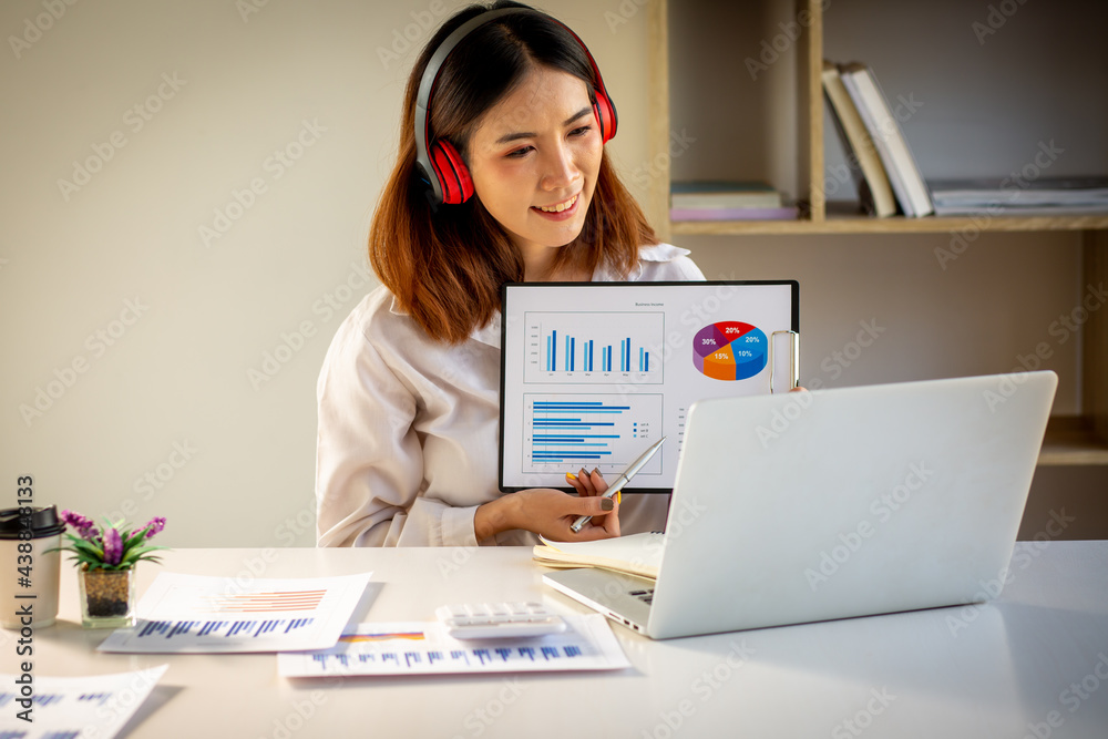 Asian Young business woman working at home with laptop and papers on desk. Asian Young business woman working at home with laptop and papers on desk.