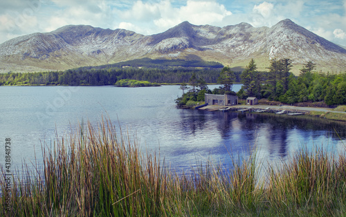 Beautiful landscape scenery of house by the lake Inagh with mountains in the background at Connemara National park in county Galway, Ireland 
