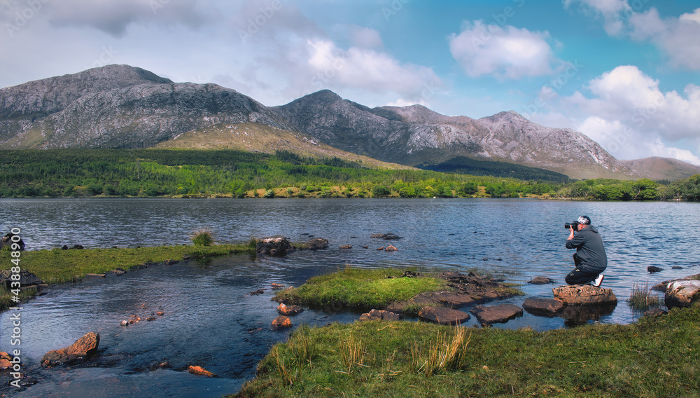 Beautiful landscape scenery with photographer by th Lough Inagh with mountains in the background at Connemara National park in county Galway, Ireland 