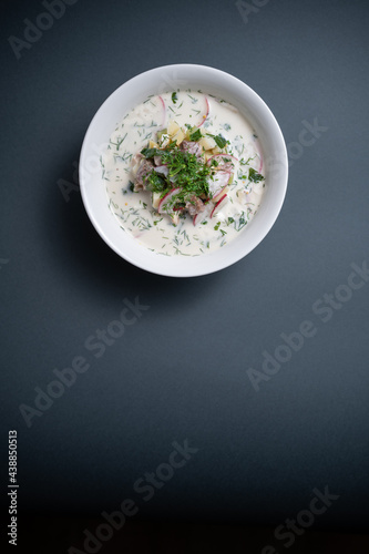 close up of russian traditional cold soup okroshka in bowl on black background