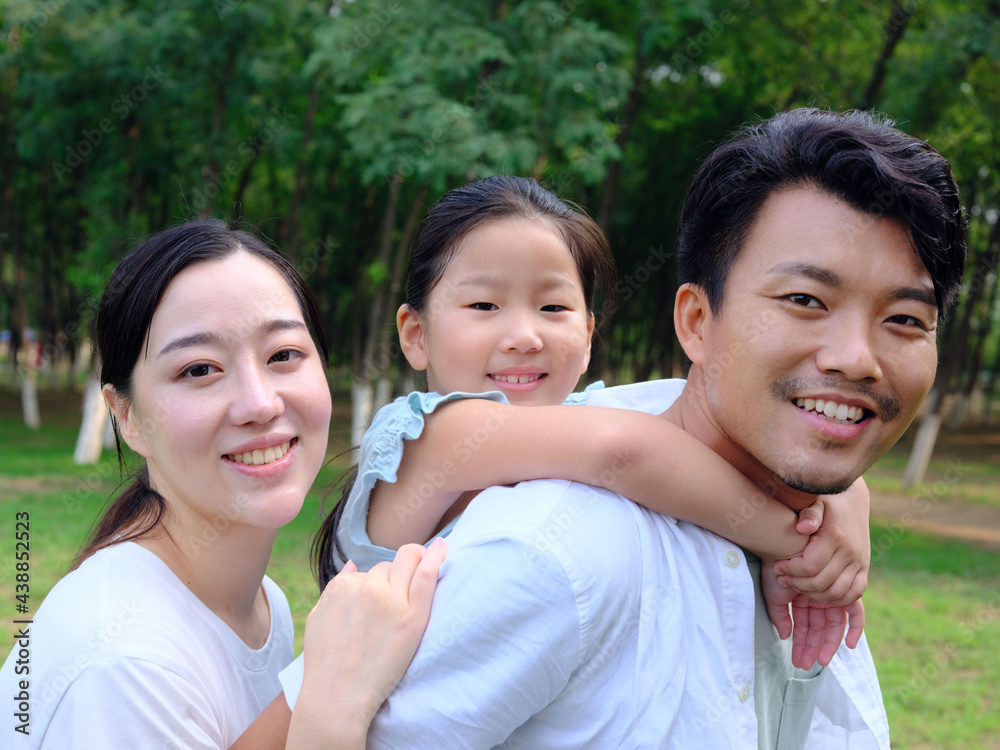Happy family of three playing in the park Happy family of three playing in the park