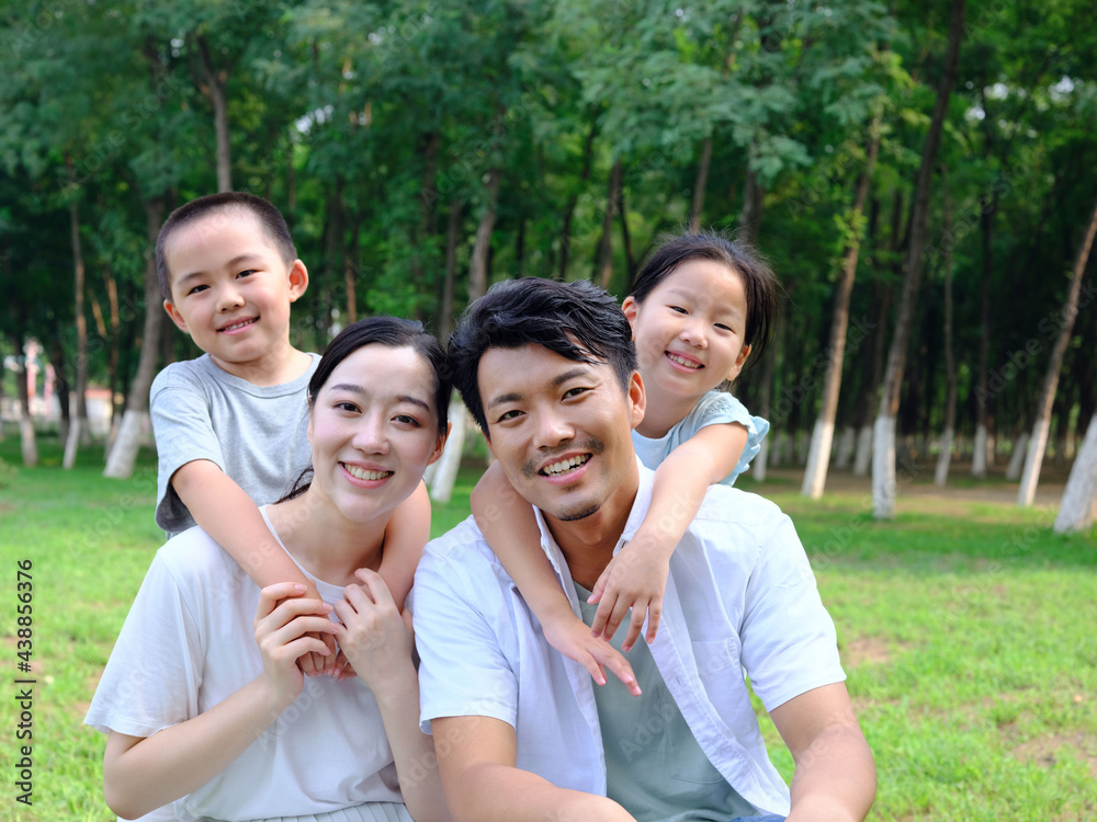 Happy family of four playing in the park Happy family of four playing in the park