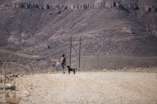 shirtless man accompanied by his dog in the desert mountains of Mexico