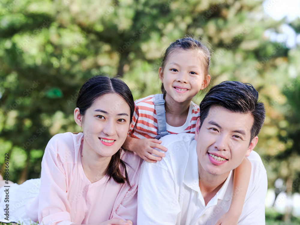 Happy family of three on the park grass