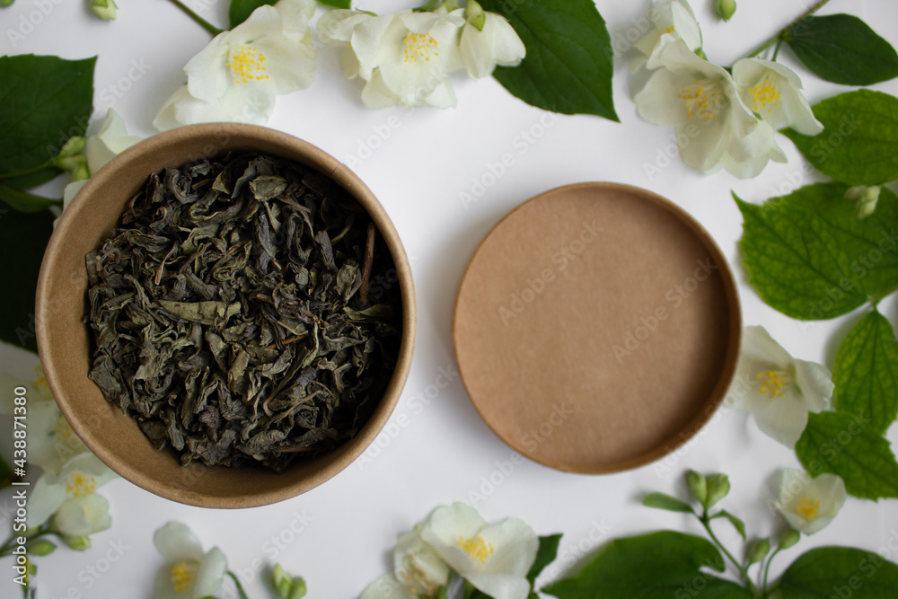 Leaf tea with jasmine in a round carton on white background. Zero waste concept