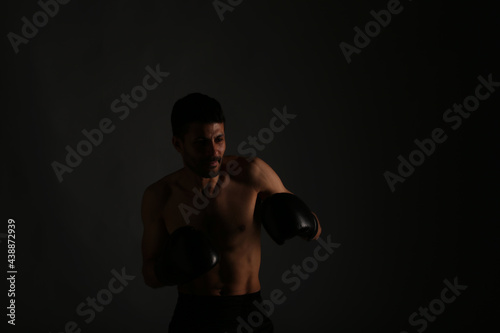 Young strong boxer fighting in shadows © Сергей Луговский