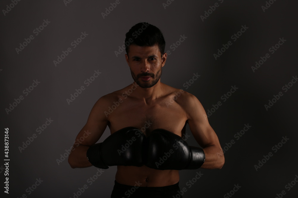 The man with boxing gloves on grey background