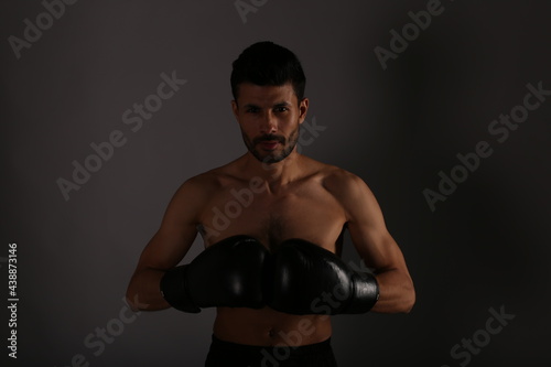 The man with boxing gloves on grey background