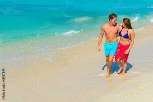 Young beautiful couple walking and relaxing on the beach 