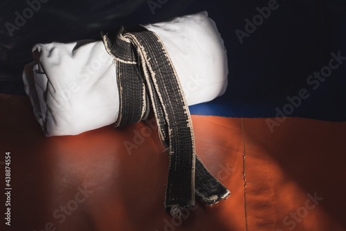 Canvas Print White kimono tied with a black belt on an orange tatami in a martial arts hall