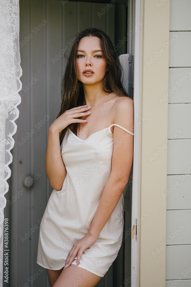 beautiful woman in summer dress and boots from stylish wooden house. beautiful woman in summer dress and boots from stylish wooden house.