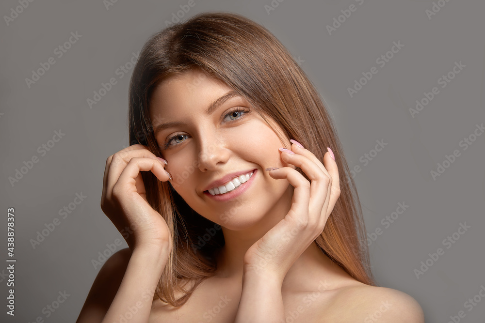 Young beautiful woman smiling on gray studio background Young beautiful woman smiling on gray studio background