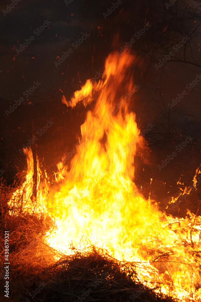 Fogo em lixão no crepúsculo com chamas altas. 