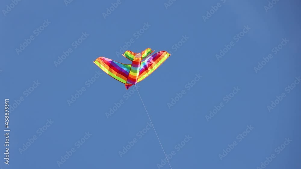 Multicolor kite hovers in blue sky 2