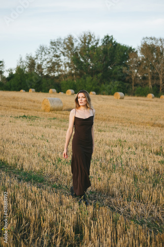 beautiful woman in dress with a chair in the field.