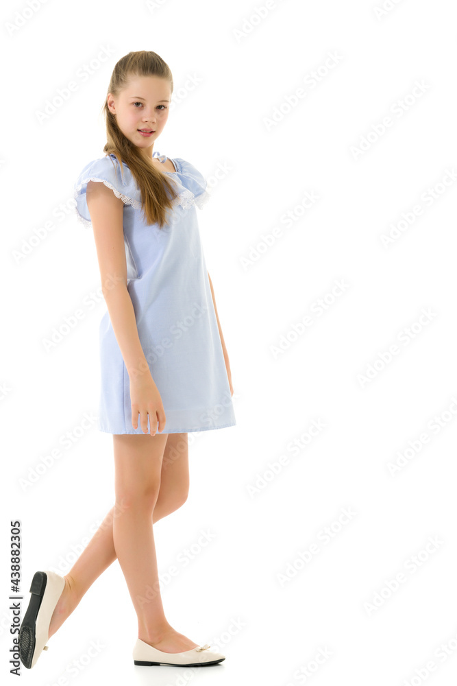 Fototapeta premium Portrait of Teen Girl in Light Blue Dress Standing Half Turn