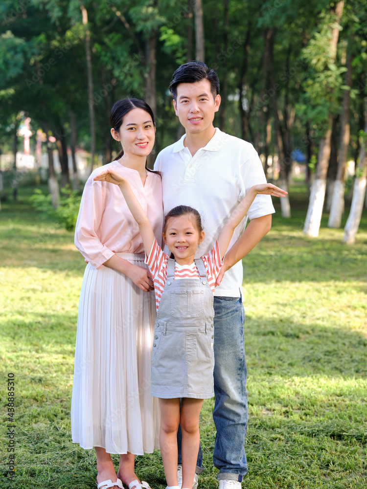 Happy family of three playing in the park Happy family of three playing in the park