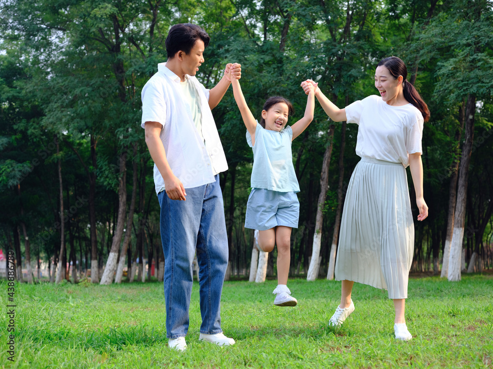 Happy family of three playing in the park Happy family of three playing in the park