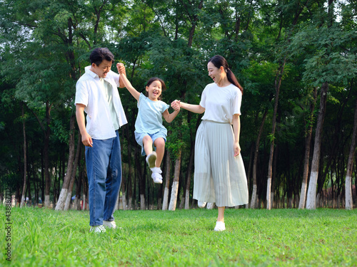 Happy family of three playing in the park