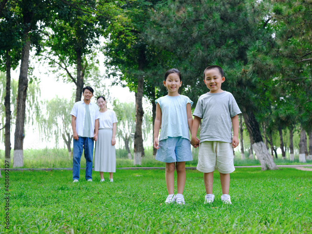 Happy family of four playing in the park Happy family of four playing in the park