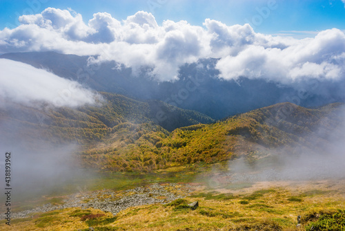 Clouds above the mountains at autumn day.