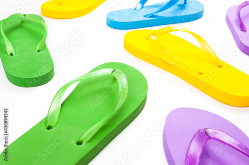 several multi colored rubber flip flops on a white background