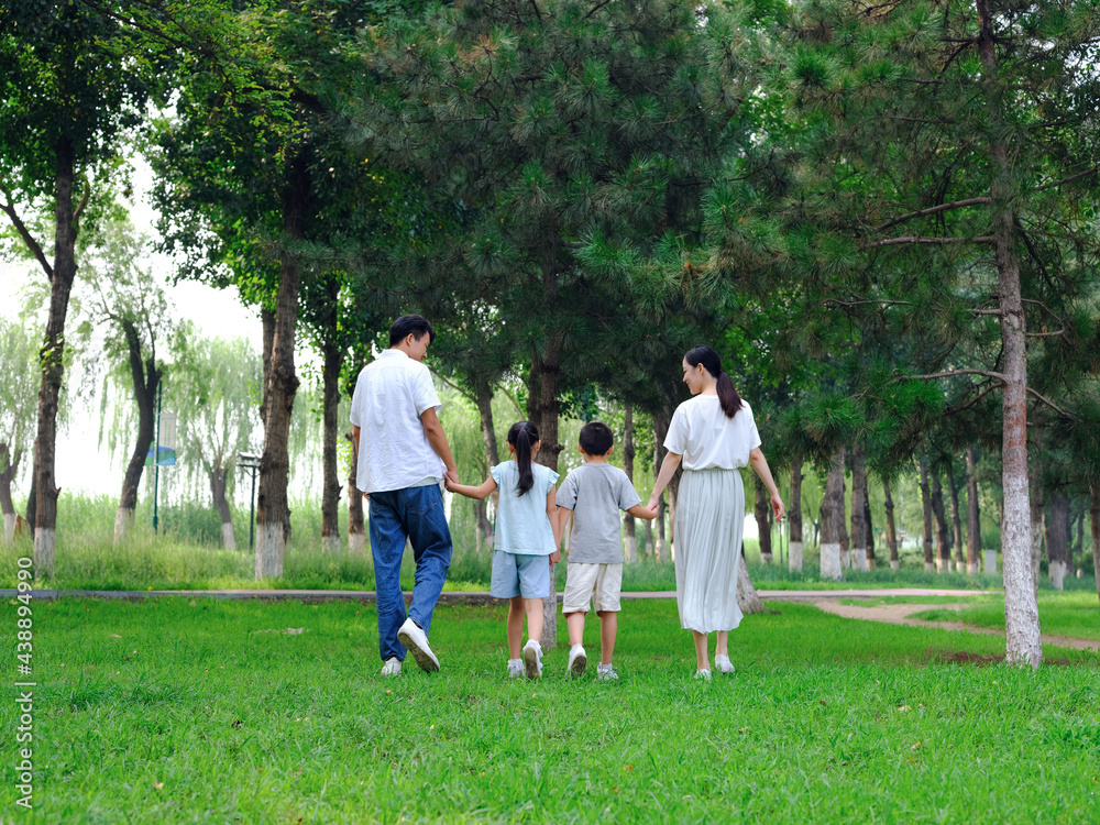 Happy family of four playing in the park Happy family of four playing in the park
