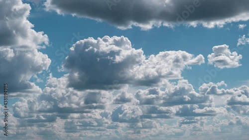 Summer clouds float across the blue sky in shuttles shape, Timelapse. Cumulus Cirrus clouds change shape. Majestic Amazing Sky. Layers of Cloud space. Change of weather. Time-lapse, Background. 4K