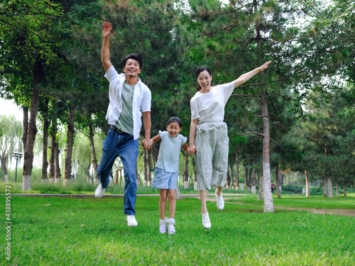 Happy family of three playing in the park