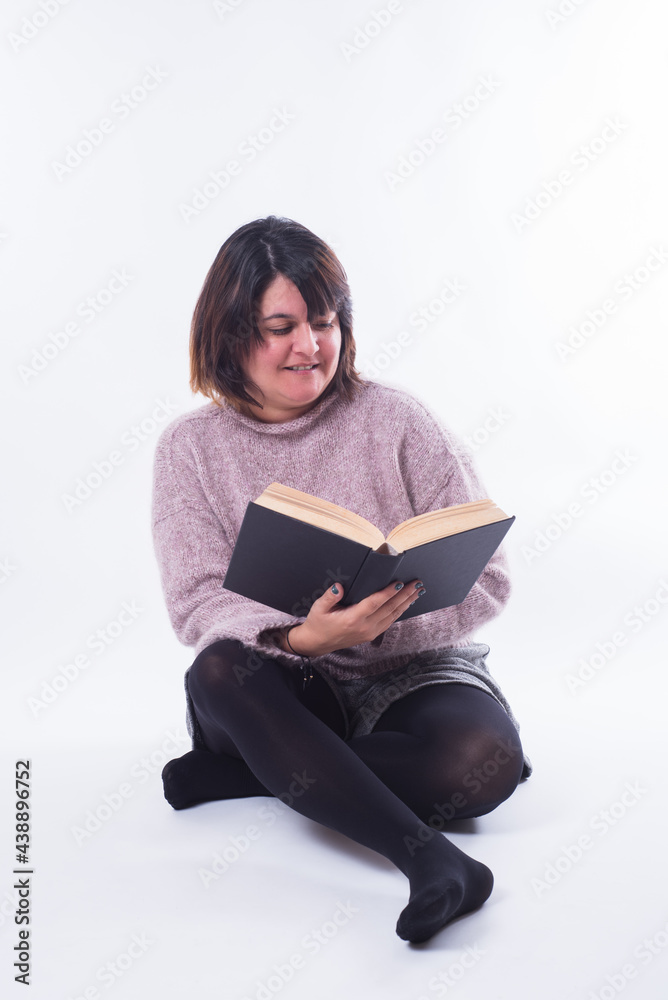 Girl sitting reading a book on white background. Copy space Girl sitting reading a book on white background. Copy space