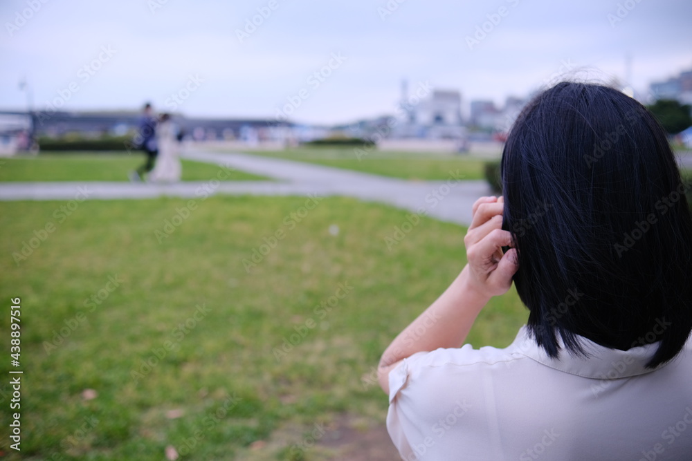 座って港を見る女性