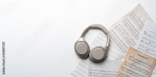 grey headphones on the music notes paper sheet