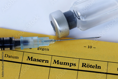 Impfung gegen Masern, Mumps und Röteln mit Impfpass, Spritze und Impfstoff photo