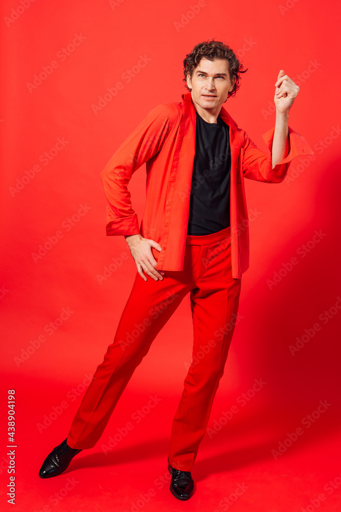 Tall handsome man dressed in red shirt posing on the red background Tall handsome man dressed in red shirt posing on the red background