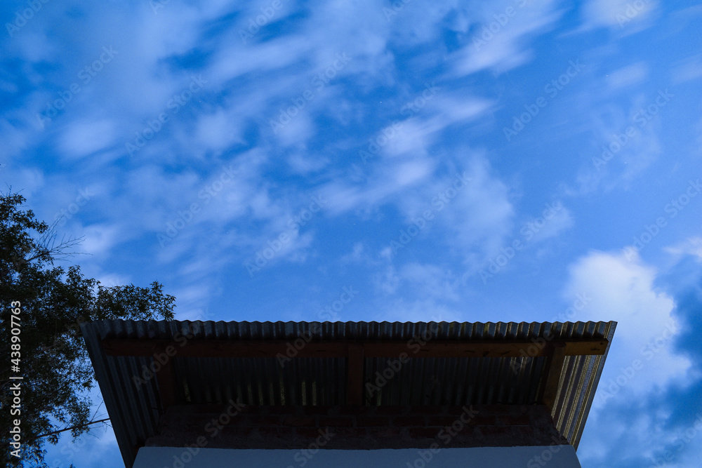 Long exposure of roof sheets from below and running clouds above rooftop Long exposure of roof sheets from below and running clouds above rooftop