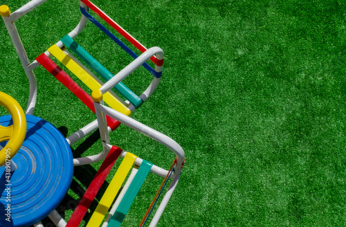 children's merry go round with several seats something old very colorful,on the left side on the grass with space for text