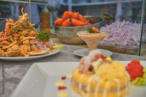 Peruvian food: Jalea de pescado or fish cracklings with fried cassava and onion salad with chili, served on a white plate. Fried seafood photo