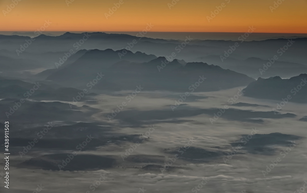 Fluffy sea of fog in a valley at sunrise time