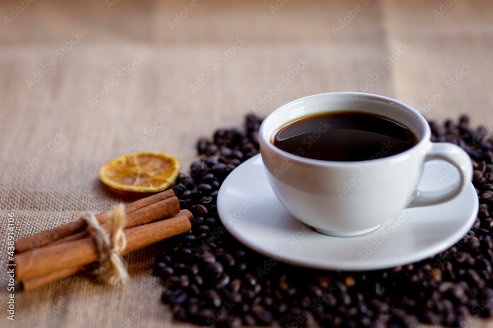 Black coffee in a white cup on a light brown cloth in the evening Black coffee in a white cup on a light brown cloth in the evening
