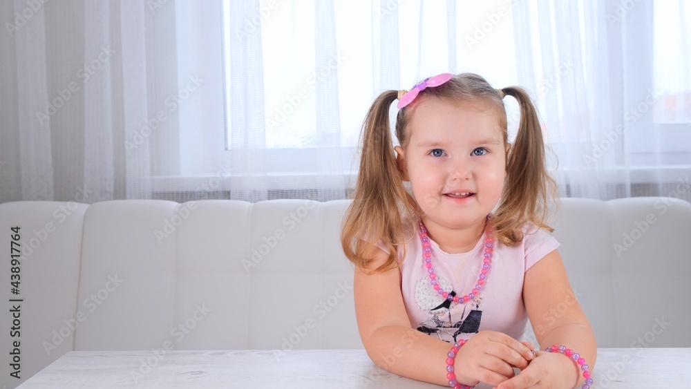 portrait of a pretty cute smiling girl 3-4 years old with big eyes and a beautiful hairstyle with a pink bow, laughing child, beads and other decorations. portrait of a pretty cute smiling girl 3-4 years old with big eyes and a beautiful hairstyle with a pink bow, laughing child, beads and other decorations.