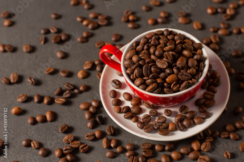 red cup with coffee beans on dark background