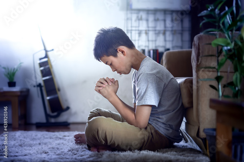 Фотография Boy pray to God in morning at home