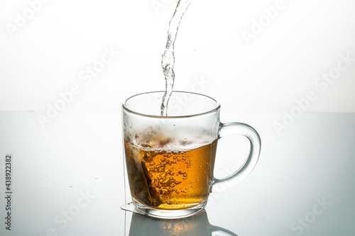 making tea from a tea bag in a transparent mug on a white background