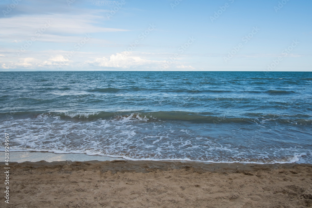 Sandy natural coastline and waves
