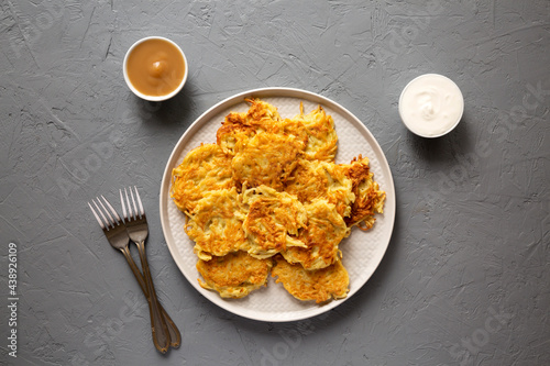 Homemade Potato Pancakes Latkes with Apple Sauce and Sour Cream on a gray surface, top view. Flat lay, overhead, from above. photo