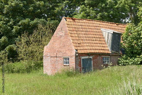 Old decaying shed with red bricks and orange tiles near Ferwert in The Netherlands.    © Harry Wedzinga