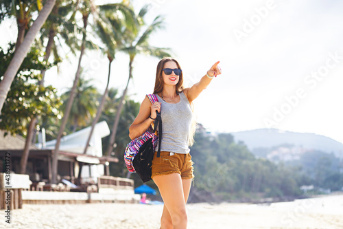 Wonderful dark-haired girl in sunglasses posing at sea resort in summer vacation